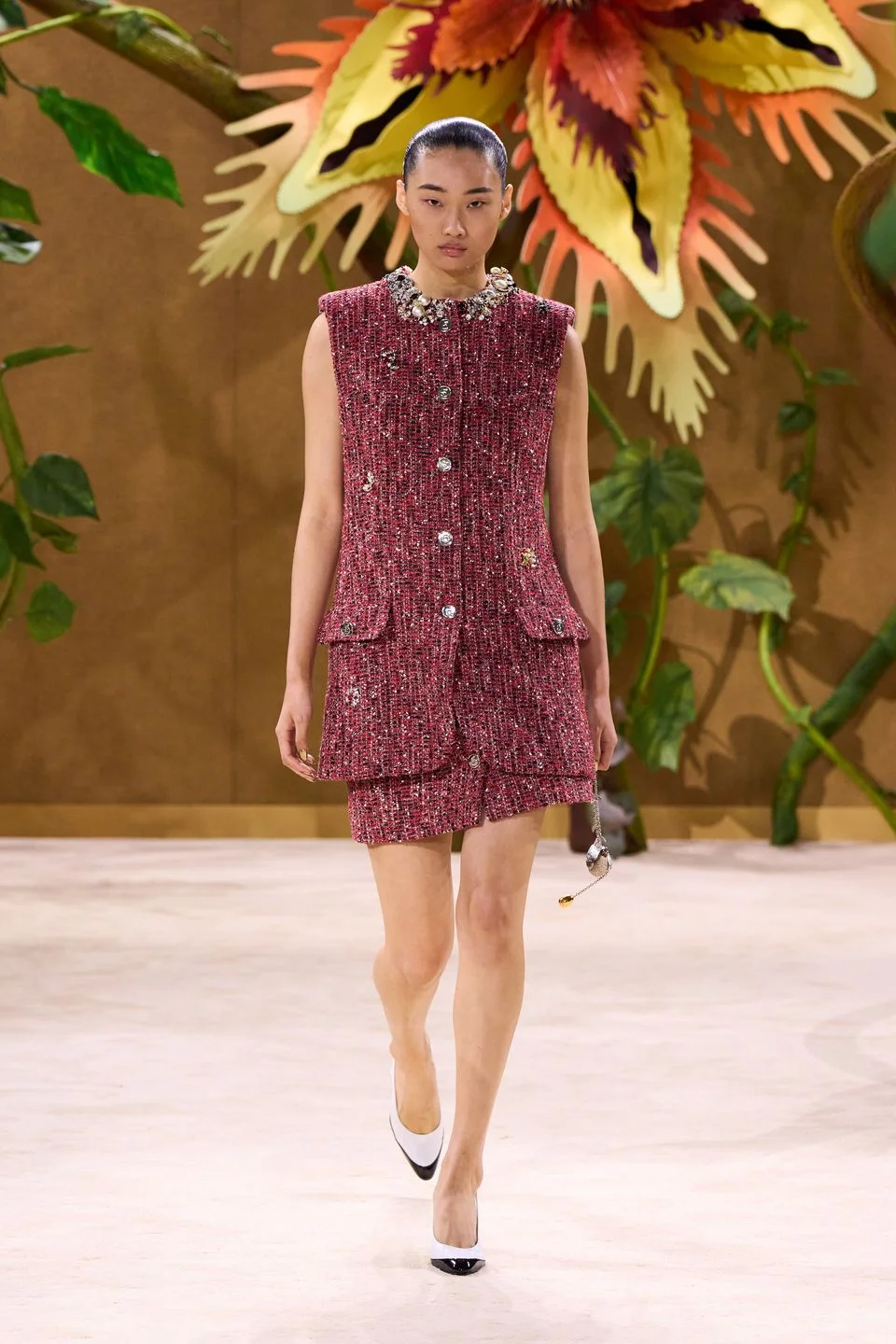 Tweed, bouclé e textura Chanel — 40%: seguem como base principal dos tailleurs, coletes, saias midi, vestidos retos e conjuntos. O diferencial é que o tweed aparece mais aberto, vazado, artesanal e, em alguns momentos, quase como treliça de jardim.